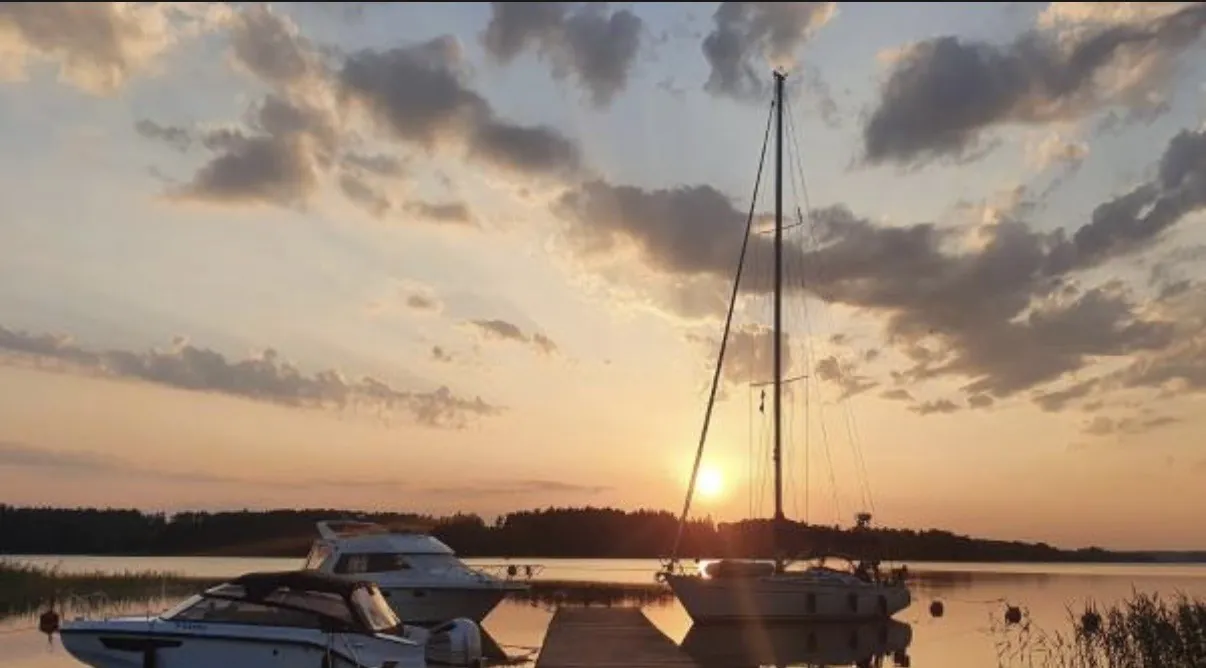 Purjevene satamassa auringonlaskussa